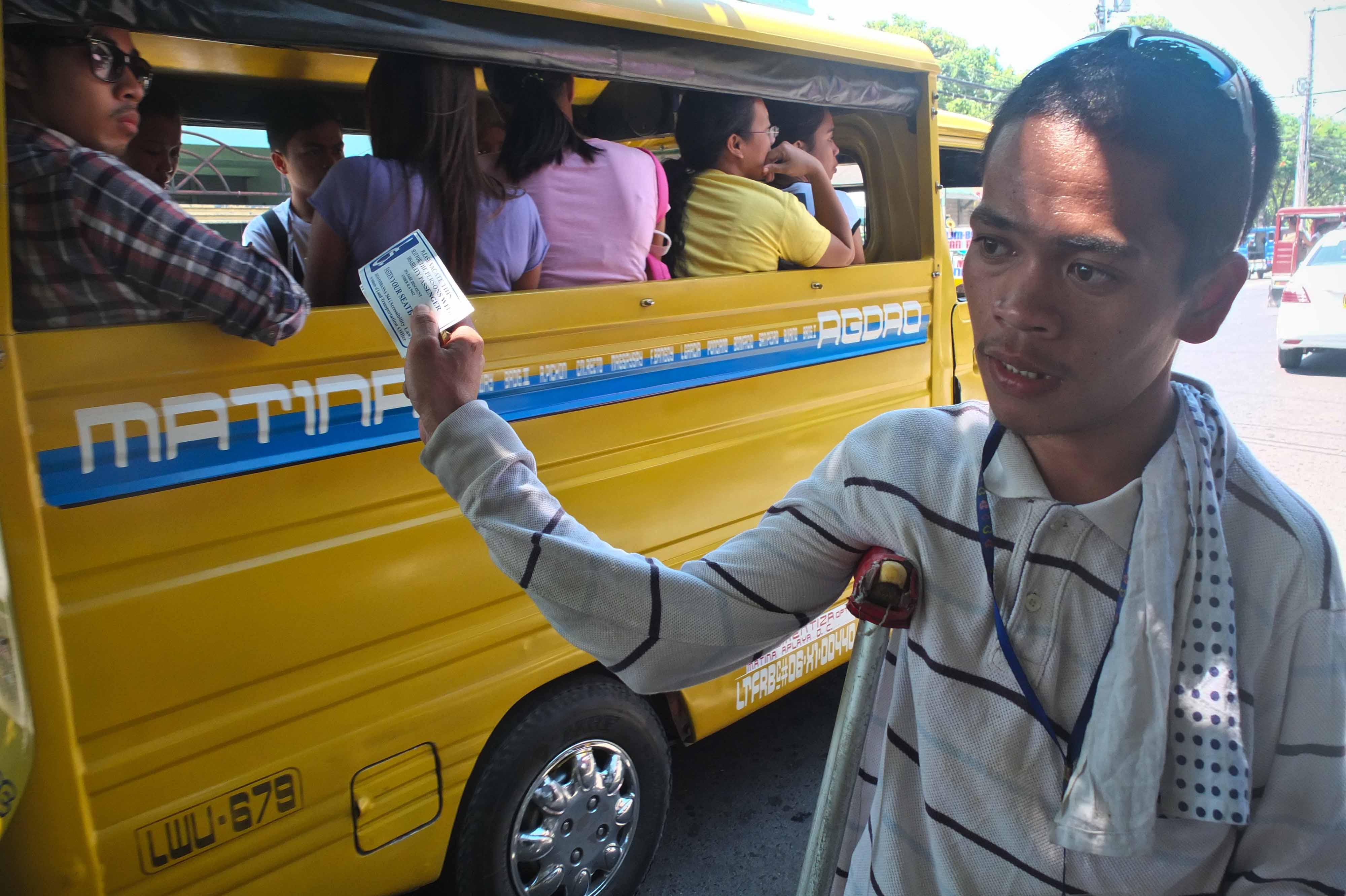 Vichard Aliño, a person with orthopedic impairment, sells stickers during the day on a mission to empower PWDs. Photo by KARLOS MANLUPIG. 