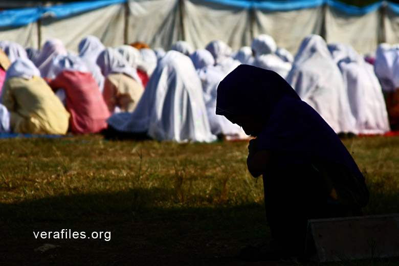 A young girl joins in the morning prayer marking Eid'l Fitr at the Tawi-tawi’s Provincial Sports Complex ground. Photo by VINCENT GO.