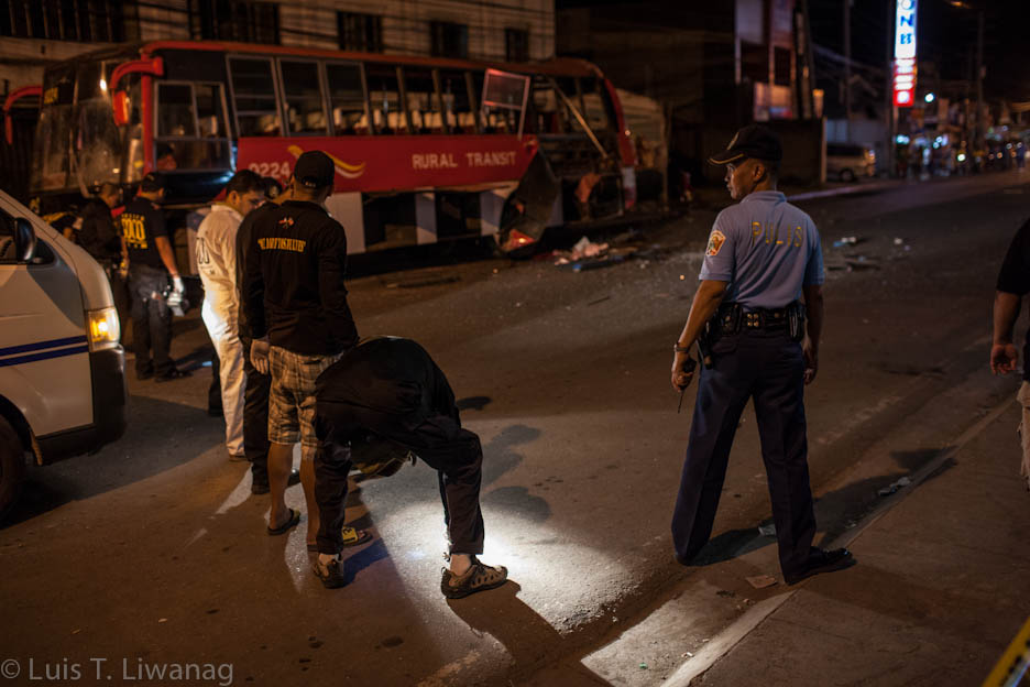 Zamboanga police sweeps the area near the wreckage after a bomb exploded as the bus was approaching the terminal in Maria Clara Lobregat Highway in Zamboanga City. Photo by LUIS LIWANAG.