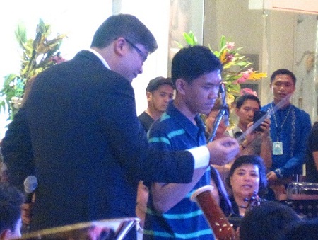 Salonga teaches young audience member a four-fourths beat so he could try conducting the orchestra