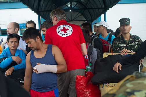 Rescuers, volunteers and civilians wait for passage at an Air Force Base in Cebu City.