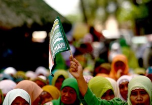 A Moro woman raises a flaglet during a gathering in Pikit, North Cotabato on Thursday (27 March 2014) to celebrate the signing of the Comprehensive Agreement on the Bangsamoro in Manila. As of 10:30 a.m., organizers said 5,000 have already arrived. (Mindanews Photo by KEITH BACONGCO) 