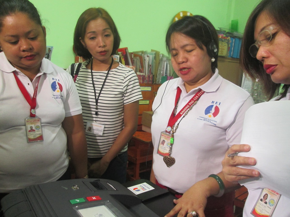 A member of the Board of Election Inspectors tries on the listening device connected to the vote counting machine (VCM) for persons with visual disability during the Feb. 13 nationwide mock elections. File photo by YVETTE B. MORALES