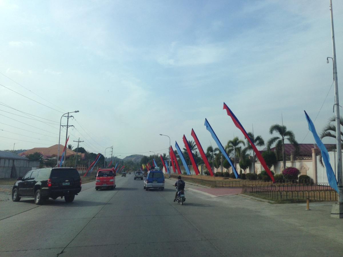 Main highway of Shariff Aguak, with the colors of the United Nationalist Alliance flying in front of the homes of Ampatuan family members. 