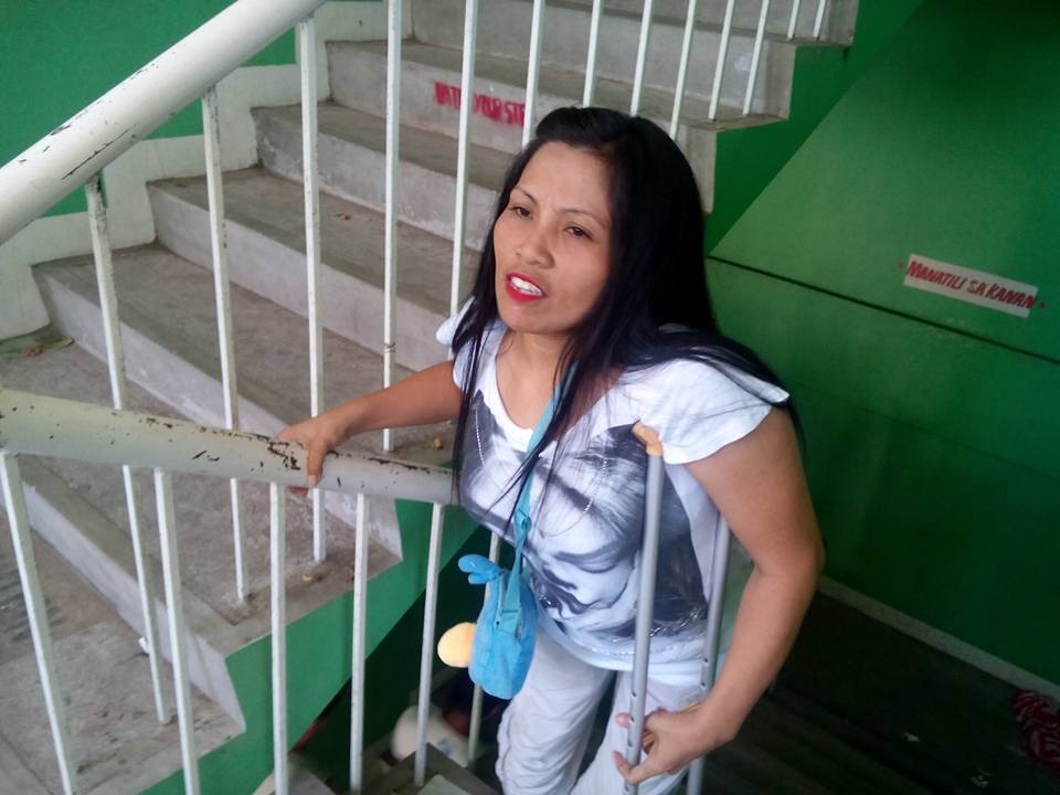 Maribel Baylen, 36, climbs up the stairs of D. P. Jimenez Elementary School in Rosario, Cavite. Photo by ‎ARIANNE CHRISTIAN TAPAO