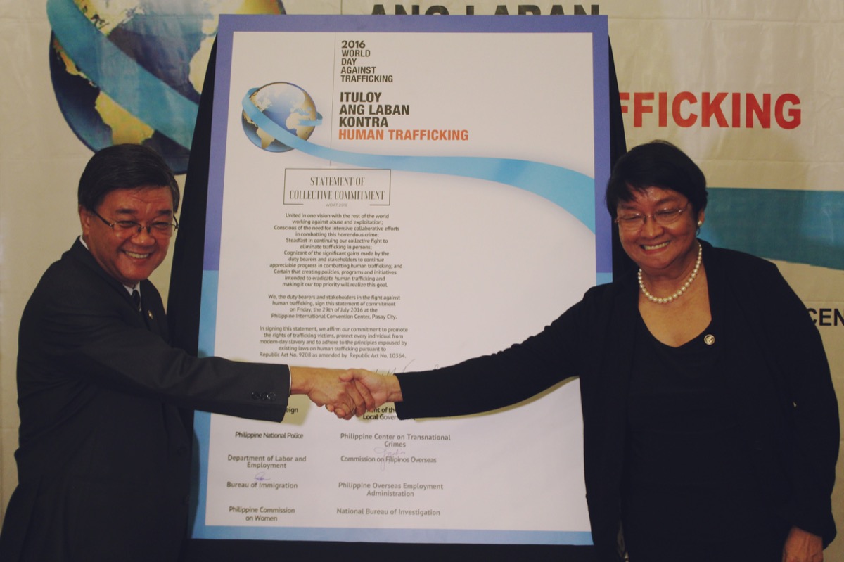 Inter Agency Against Trafficking Council’s chair Justice Secretary Vitaliano Aguirre II and vice chair Social Welfare and Development Judy Taguiwalo sign a pledge of commitment in reinforcing the government’s effort to monitor trafficking in person cases in the country during the celebration of the 2016 World Day Against Trafficking at the Cultural Center of the Philippines, July 29. Photo by PAUL JOHN DOMALAON
