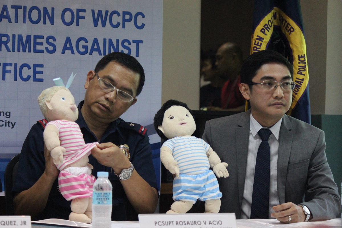 Philippine National Police Women and Children Protection Center’s Chief Rosauro Acio and International Justice Mission’s Florencio Inocencio hold dolls used to teach school children what parts of their body cannot be touched by anyone. Photo by PAUL JOHN DOMALAON