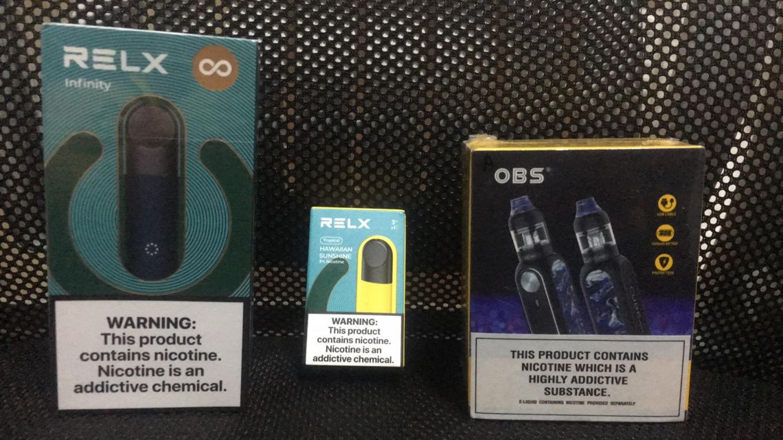 A set of a compact-sized Relx vape pod and the cartridge bought on Shopee (left and middle), and the tank-type device bought on the website (right).