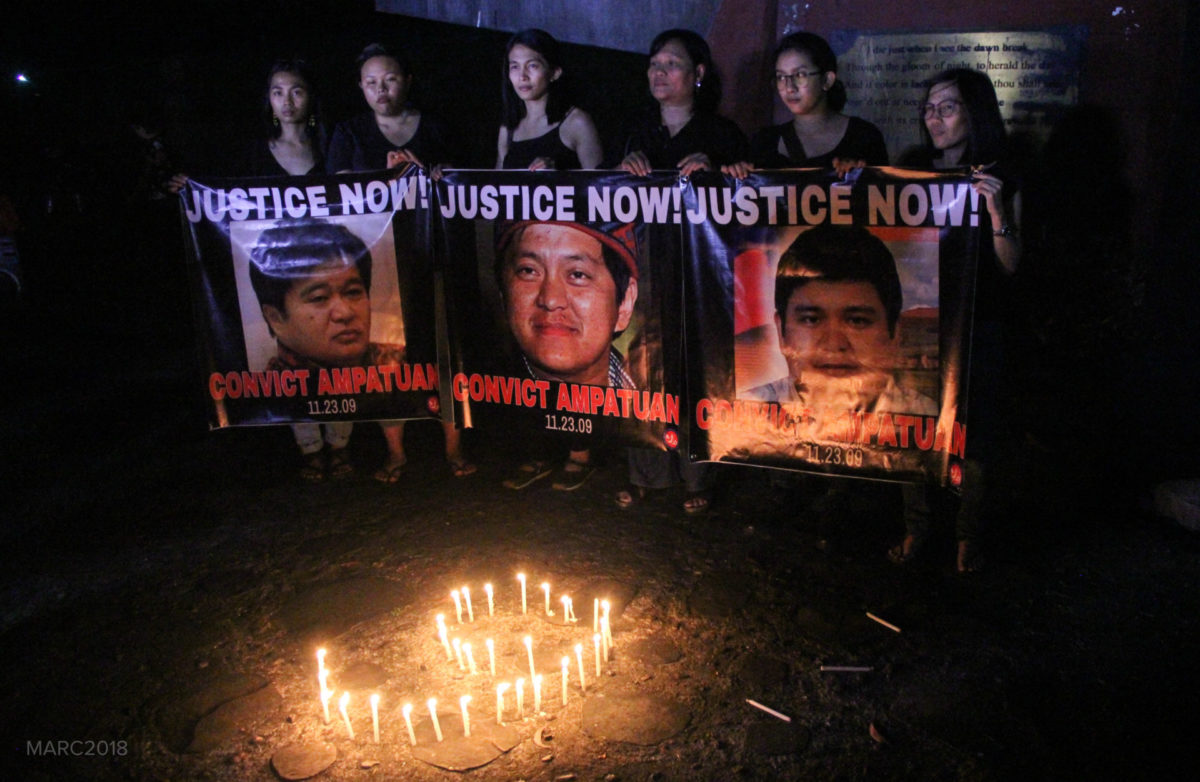 Advocates pose for a photo with their “CONVICT AMPATUAN” posters to end the candle lighting activity.