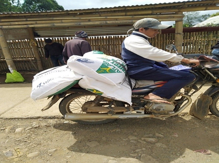 A rider carries sacks of goods on his motorcycle.