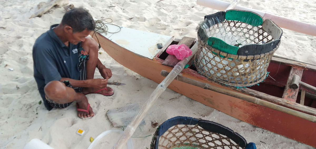 Pamilacan fisher prepares fish hooks for palangre, a vertical fish hooking method. Photo by Cooper Resabal.