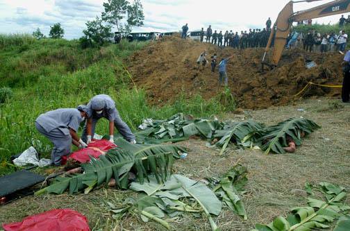 Authorities use a backhoe to recover the remains of 58 individuals murdered by members of the Ampatuan clan in November 2009 on the hills of Ampatuan town, Maguindanao. Photo by Froilan Gallardo