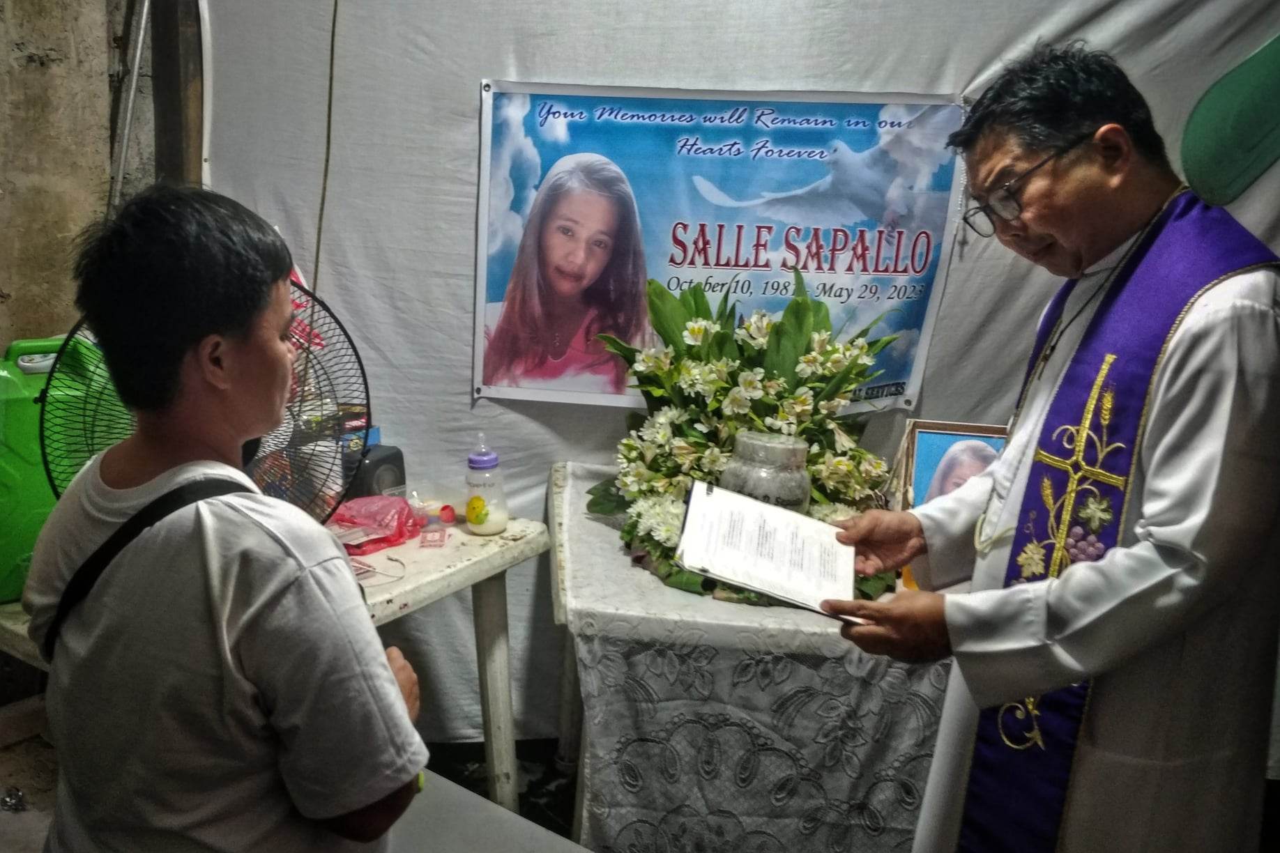 Fr. Flavie Villanueva, head of Program Paghilum, which takes care of families of victims of  the drug war, condoles with the family of Salle Sapallo, who was killed in a police drug operation in Navotas on May 29. Photo by Vincent Go.