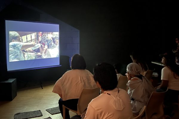 Audience members watch and listen to the documentary and poem dedicated to Baby River Nasino. Photos by John Irving Gandia