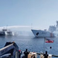 Chinese Coast Guard ship (white) was caught on cam firing a water cannon at a Bureau of Fisheries and Aquatic Resources (BFAR) vessel (black) on Dec. 9 near Bajo De Masinloc (Scarborough Shoal) in the West Philippine Sea. The incident happened during BFAR’s oil and grocery supply mission to Filipino fishing vessels near the shoal. (Photo grabbed from a video posted on Dec. 12 by Philippine Coast Guard’s official Facebook page.)