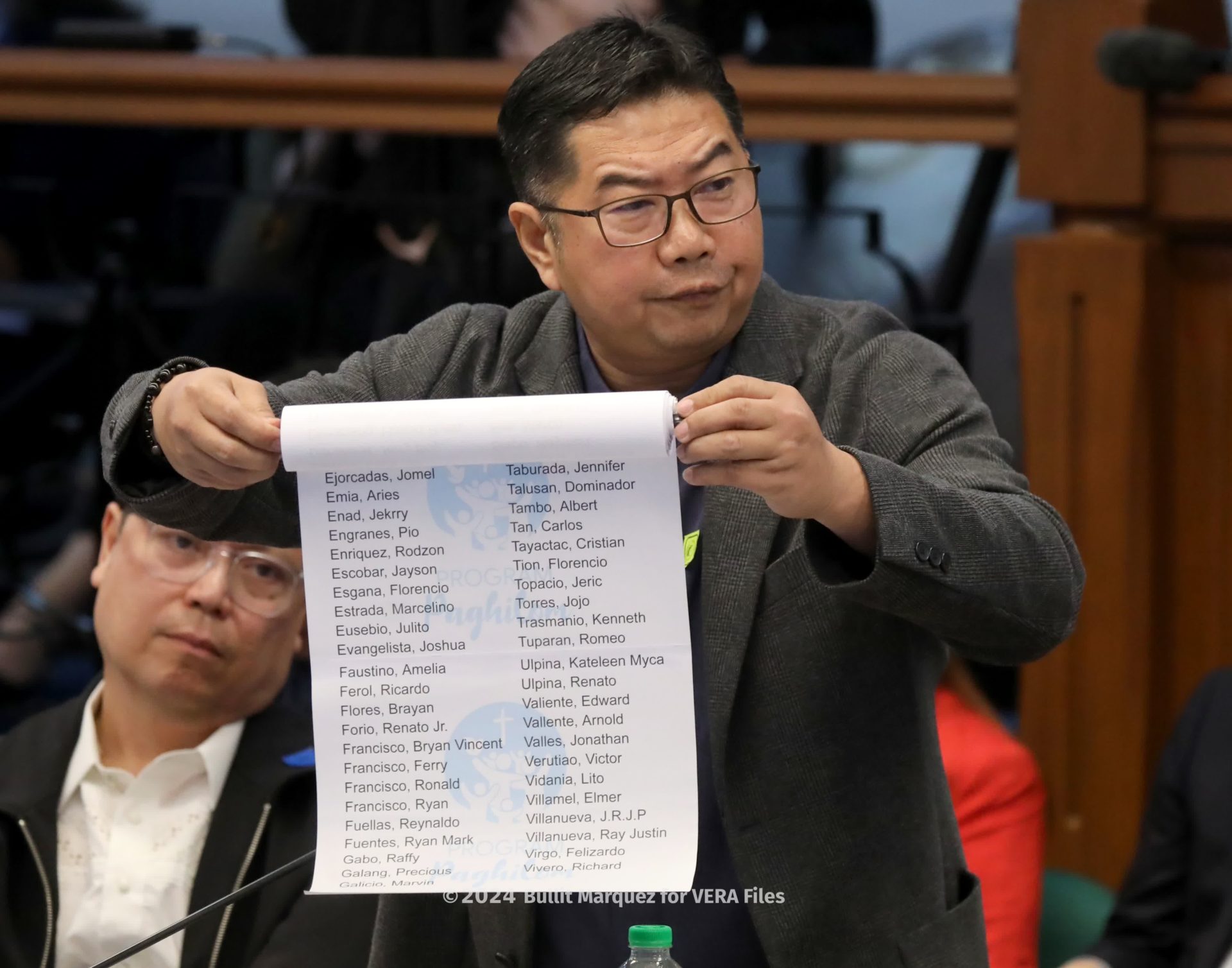 Fr. Flavie unfurls the list of more than 300 victims of extra-judicial killings. Photo by Bullit Marquez