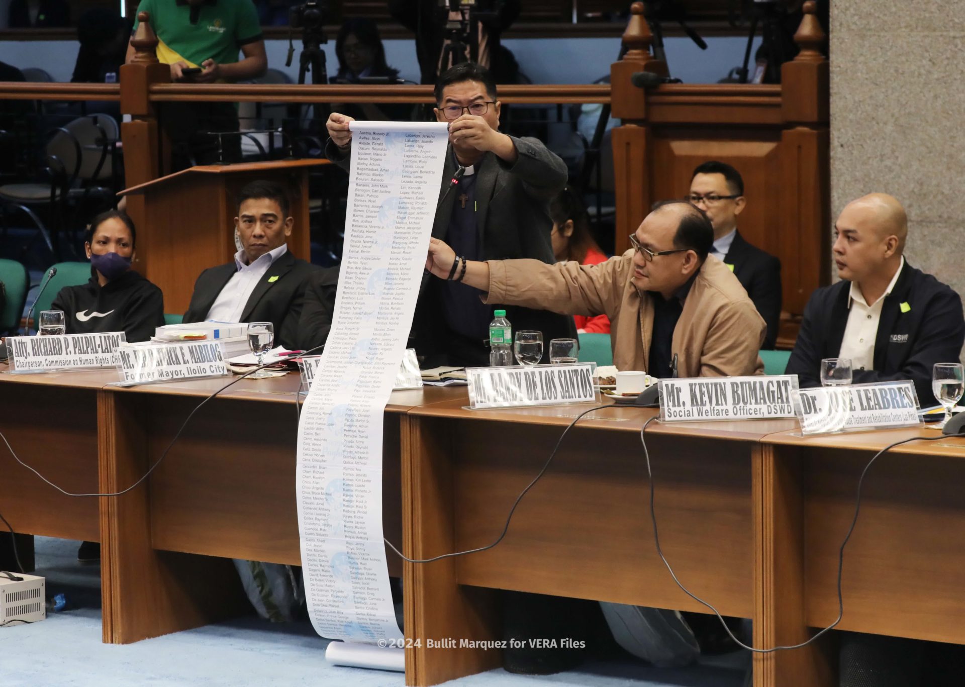 Fr. Flavie unfurls the list of more than 300 victims of extra-judicial killings. Photo by Bullit Marquez