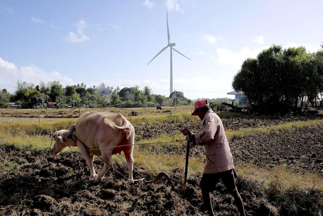 A farmer works near a wind farm on the Philippine island of Guimaras. Lack of access to electricity is one thing activists hope the growth in renewables will address (Image © Veejay Villafranca / Greenpeace)