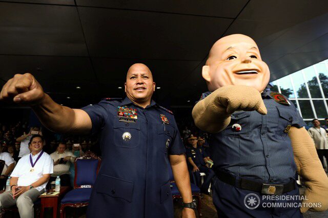Then-Philippine National Police Chief Bato Dela Rosa smiles with PNP mascot “PO1 Bato” in Camp Crame on Aug. 1, 2016. Photo by Toto Lozano/PPD and PCO. 