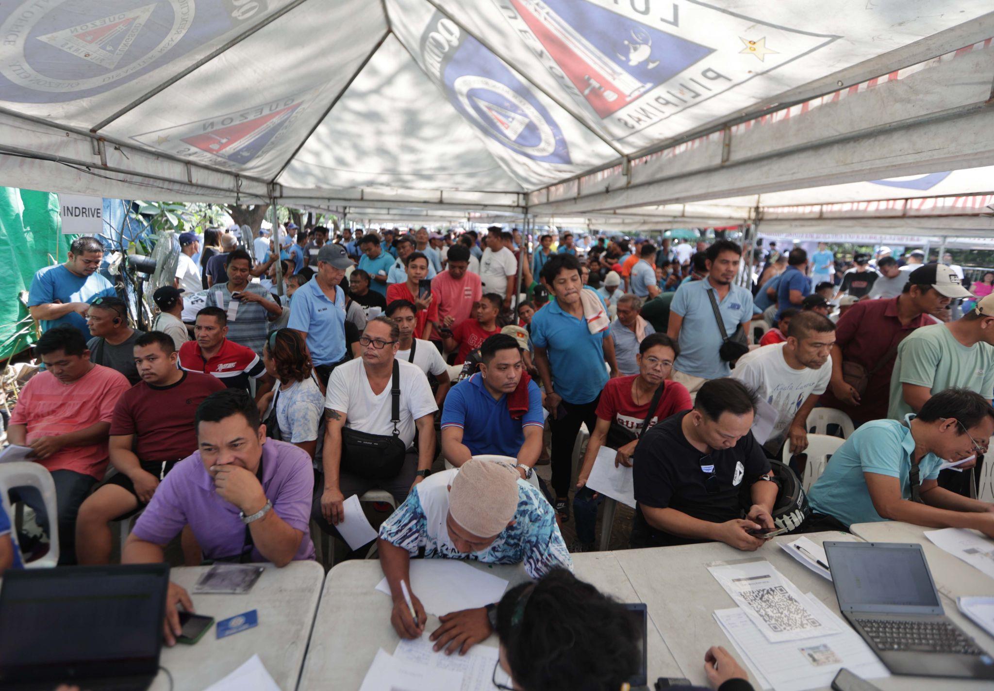 Line up. Fill out forms. Wait. Drivers queue for ayuda that still eluded many.