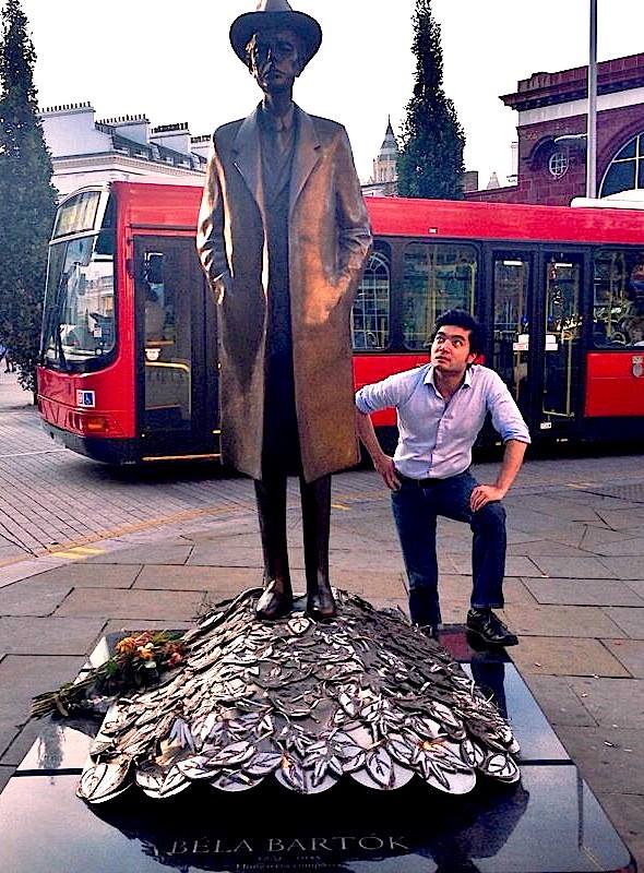 The conductor with the statue of composer Bela Bartok in London.