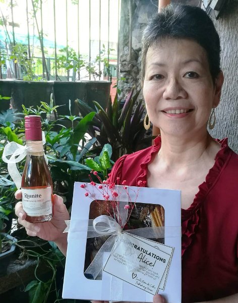 Dr. Alice Sun Cua posing with gifts from the Sto. Nino de Cebu Publishing House