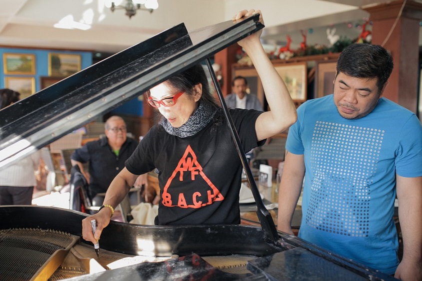 Autographing an antique grand piano at Iggy's Inn with manager Louie Bautista witnessing.jpg