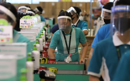 Business as usual for employees at a local supermarket as they work with personal protective equipment. PNA file photo.