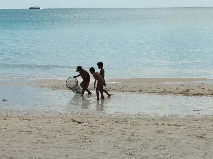 Photo 4 - Kids play with fishing net along the white beachfront..jpg