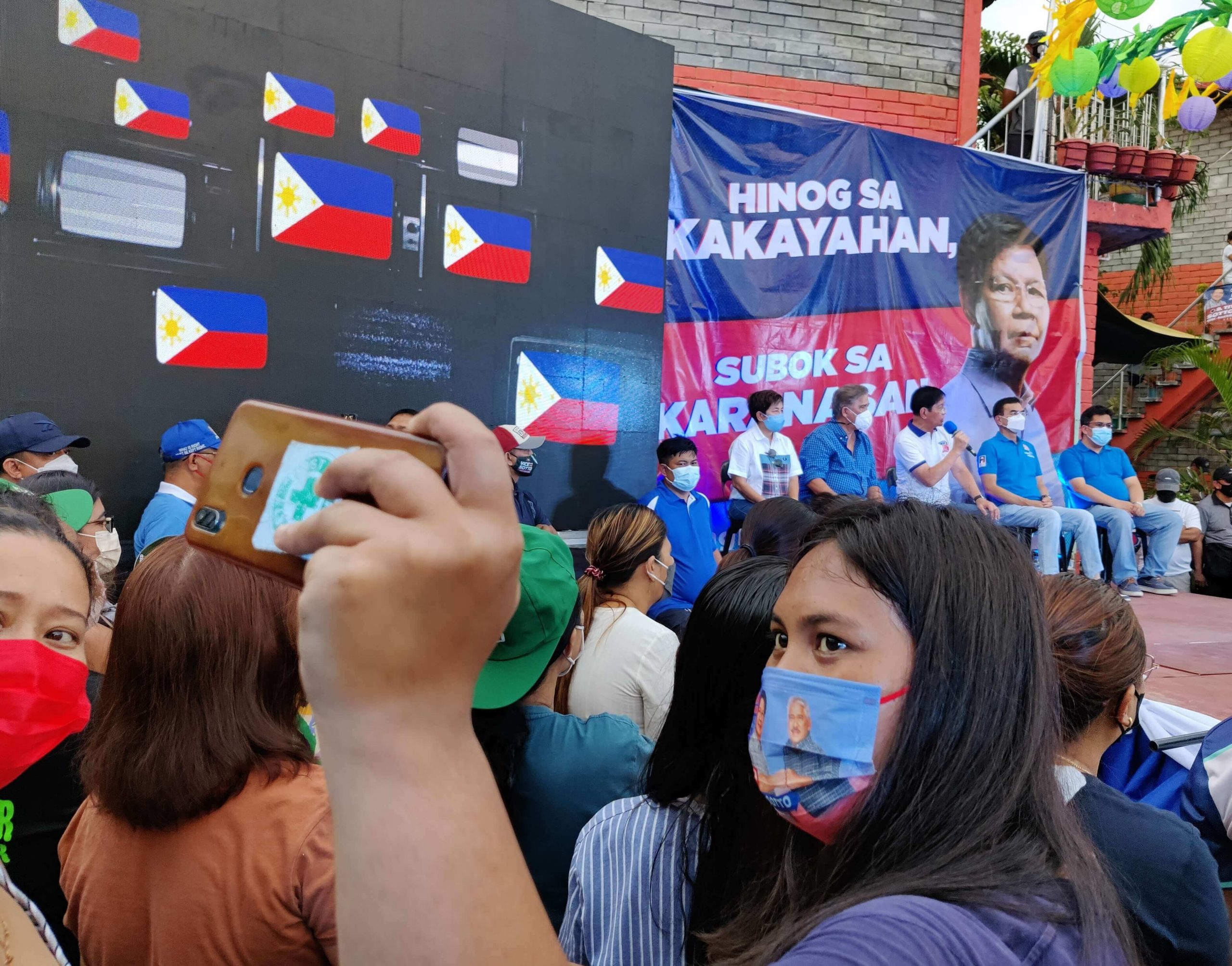 A woman raises her smartphone to take a selfie as the Lacson-Sotto tandem answers questions during the March 26 town hall meeting at Brgy. 165, Malibay, Pasay City. Photo by Enrico Berdos/VERA Files