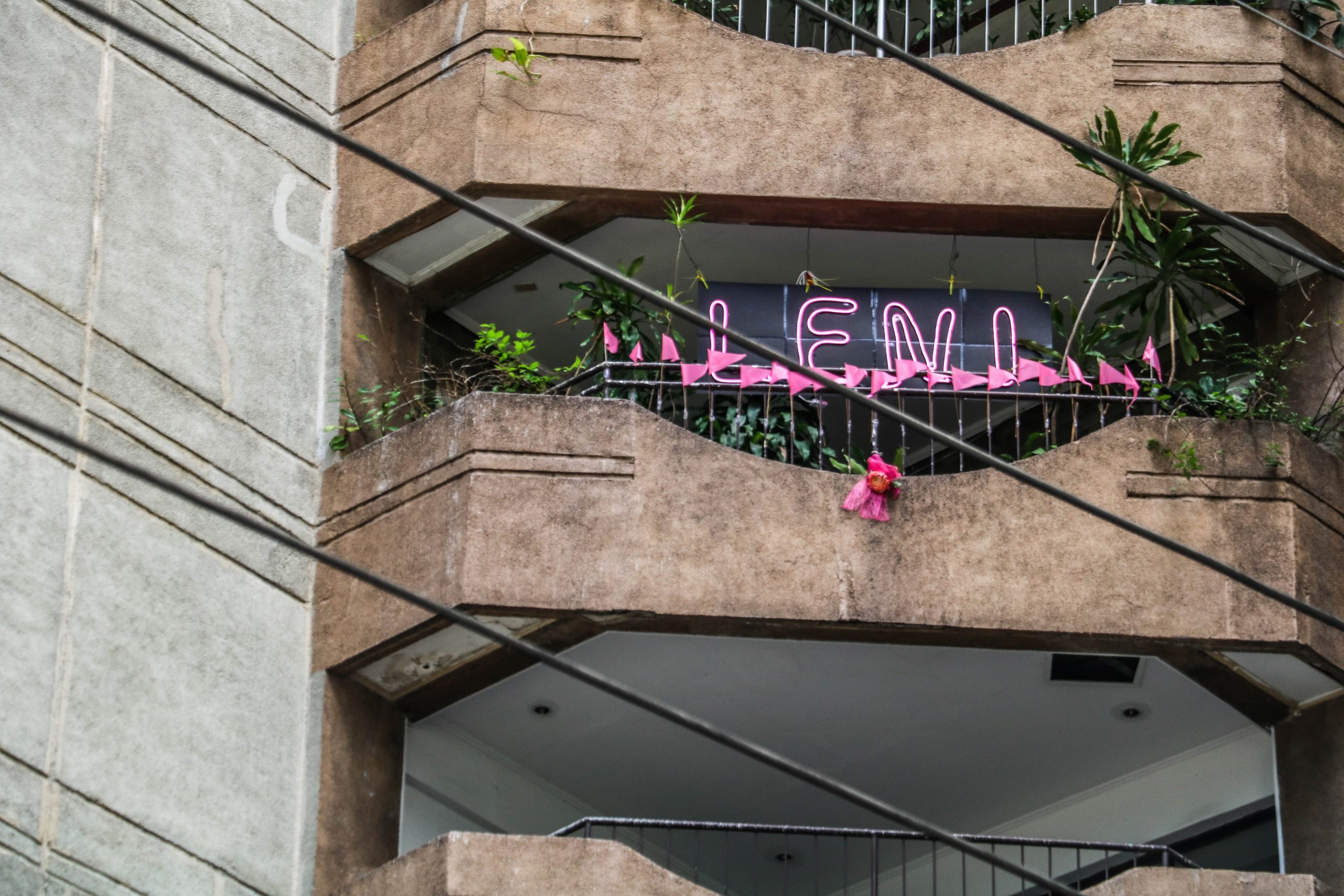 Residents of a Pasig residential tower display signs for Leni. At night, some of the signs light up in pink, the candidate’s campaign colors.